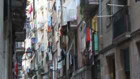 Calle estrecha llena de ropa colgada de los balcones en el barrio del Raval de Barcelona
