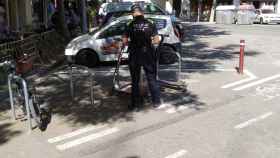 Un guardia urbano sanciona a dos patinetes eléctricos de una empresa estacionados en unos aparcamientos de bici / JORDI SUBIRANA