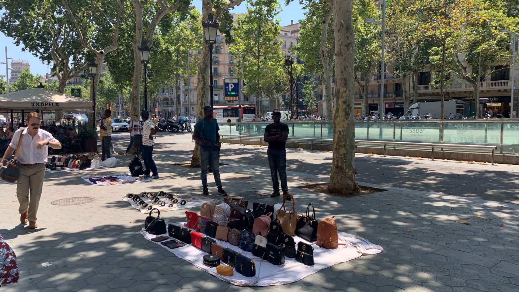 Manteros vendiendo productos falsificados en paseo de Gràcia
