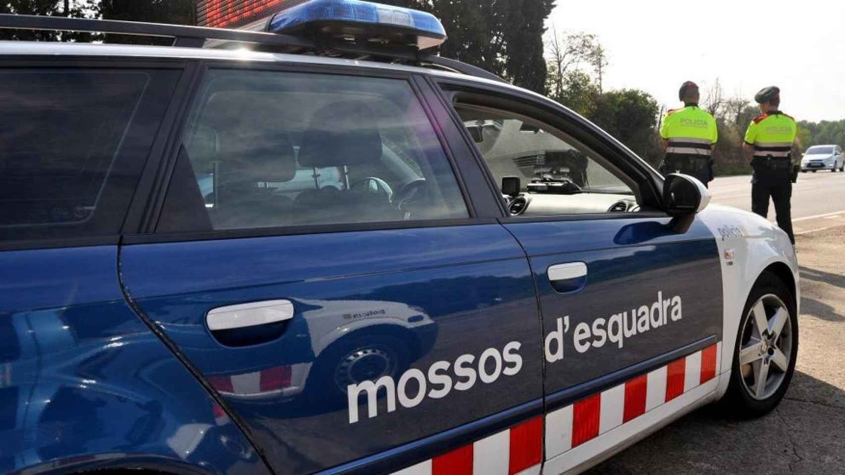 Vehículo de los Mossos d'Esquadra junto a dos agentes uniformados / Mossos