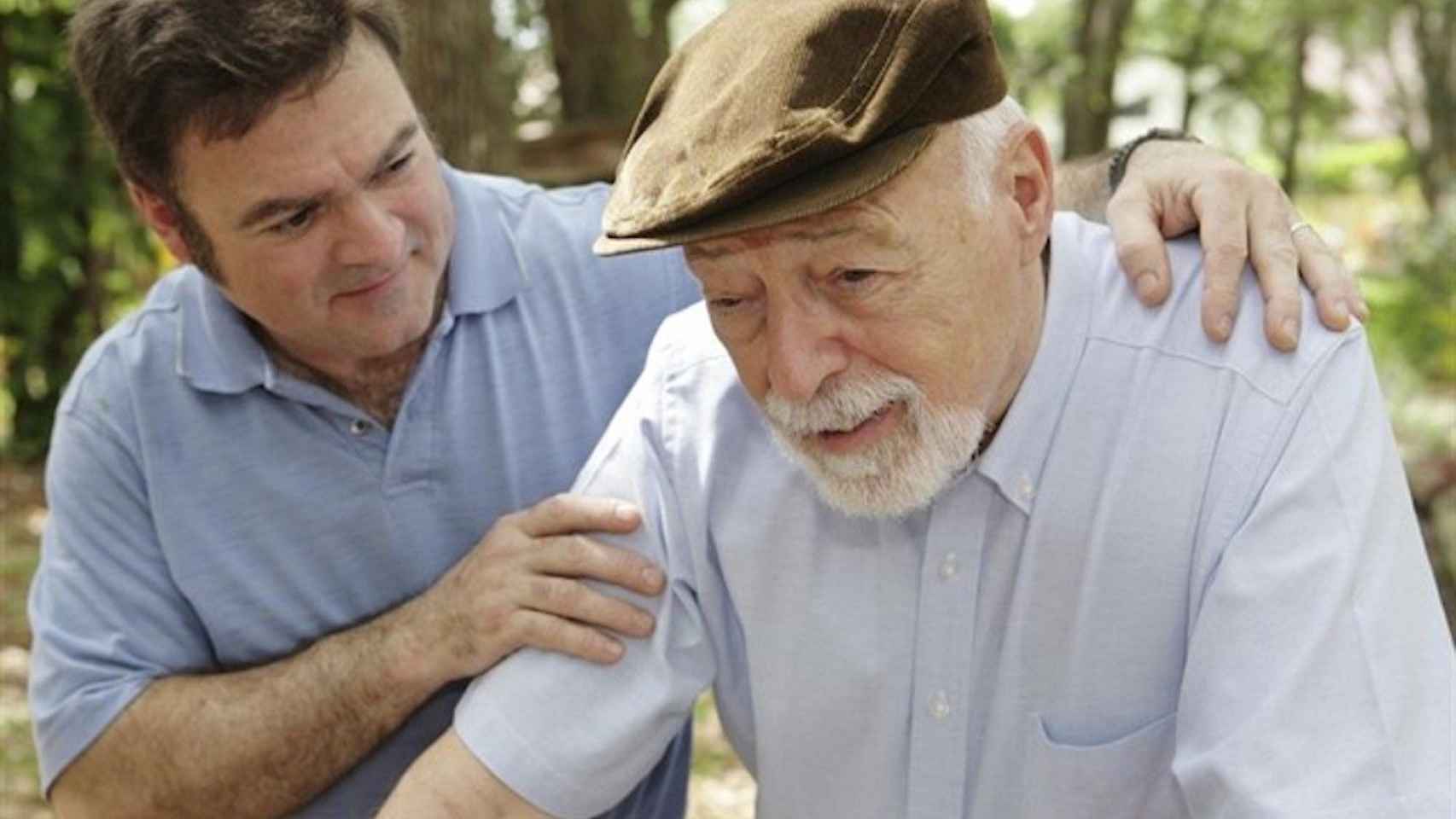 Una imagen de archivo de un anciano con alzheimer junto a su cuidador