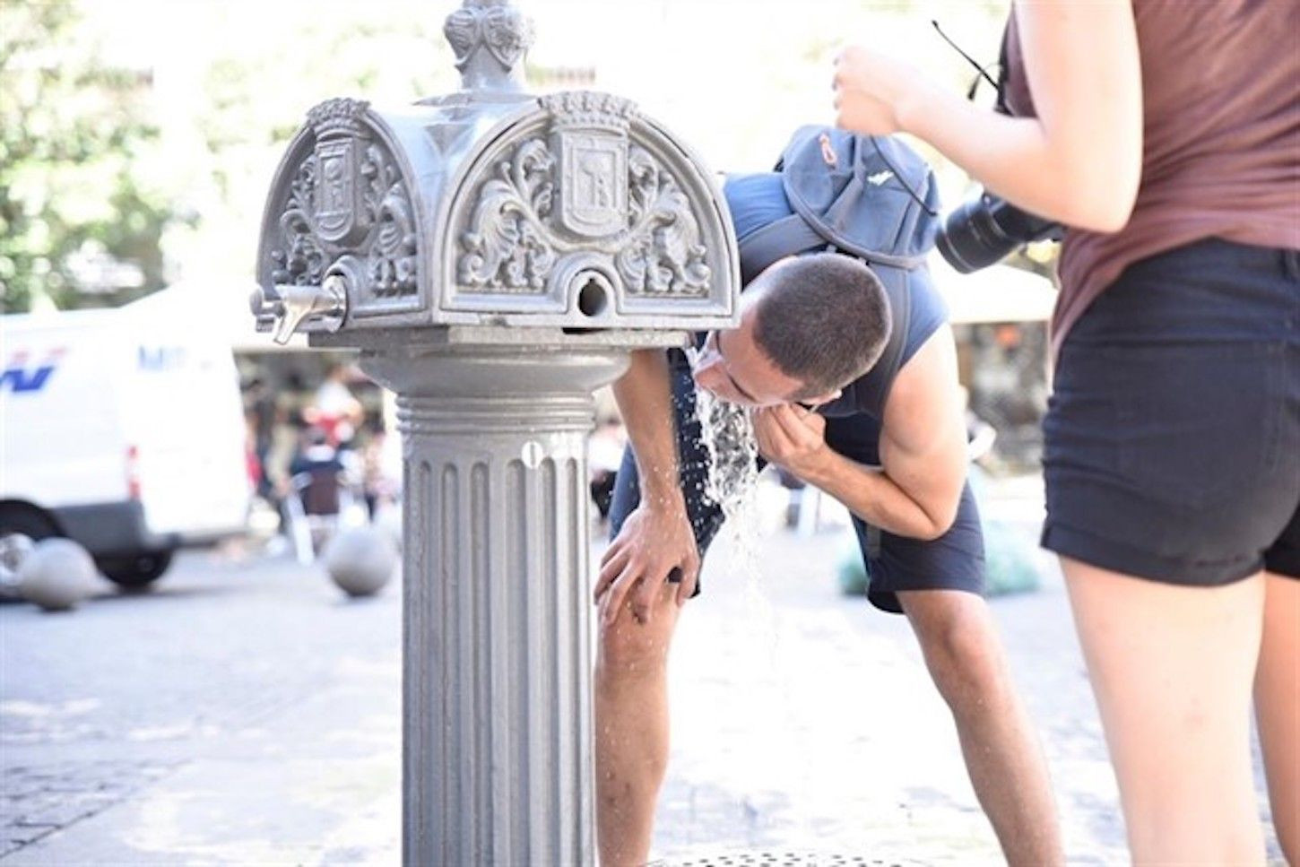 Dos personas se hidratan en una fuente de Barcelona por la ola de calor / EUROPA PRESS