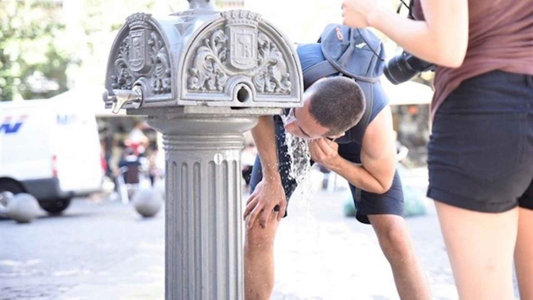 Dos personas se hidratan en una fuente de Barcelona por la ola de calor / EUROPA PRESS