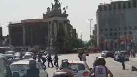 Agentes de los Mossos d'Esquadra, a punto de reducir al hombre junto a la plaza de Espanya / TWITTER OSCARNEITOR