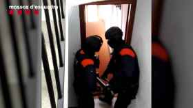 Agentes de los Mossos d'Esquadra entrando en una de las viviendas de los detenidos acusados de estafar a ancianos / Mossos