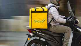 Un repartidor de Glovo montado en una motocicleta y con una mochila de la compañía