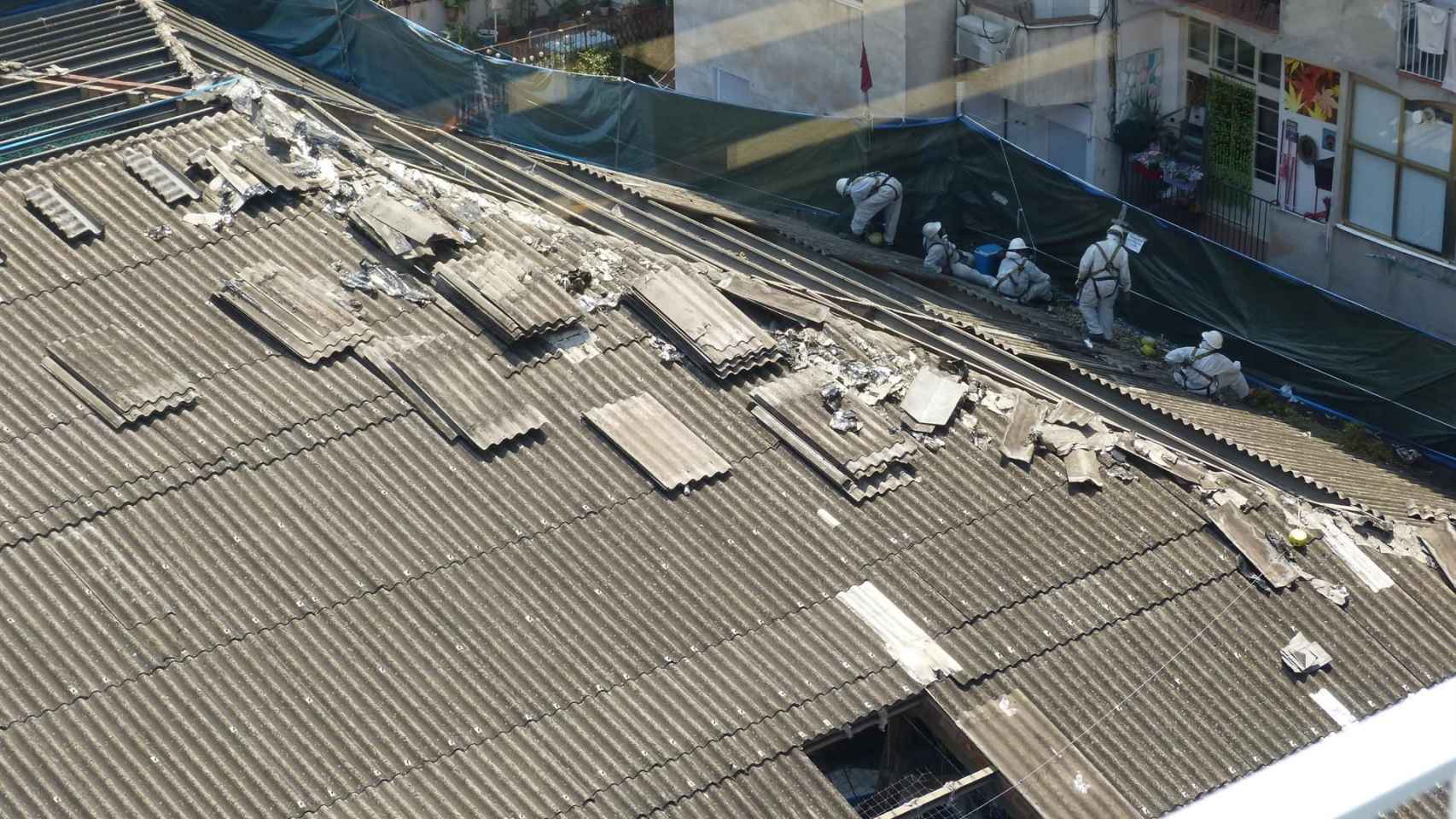 Operarios trabajando en la retirada de amianto del tejado del antiguo Cine Urgell / EP