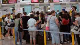 Varias personas esperan este sábado frente los mostradores de la aerolínea Vueling en el aeropuerto del Prat de Barcelona / EFE-Alejandro García