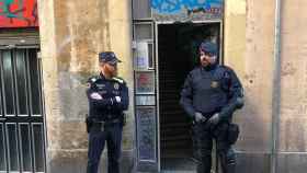 Dos agentes del cuerpo policial delante de una vivienda en Barcelona / EP
