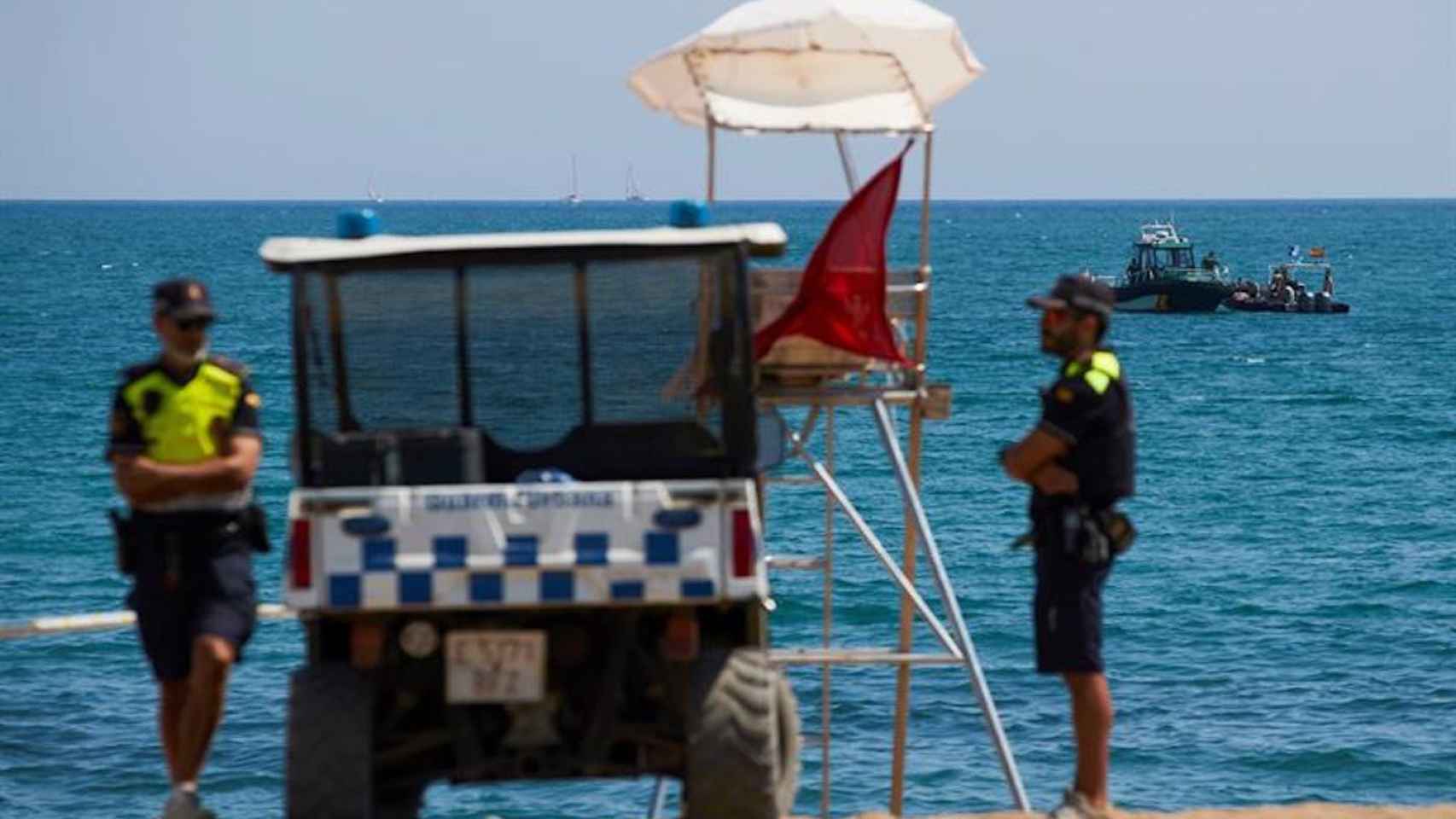 Dos policías en una de las playas de Barcelona que han sido cerradas con bandera roja por la mala calidad del agua / ARCHIVO