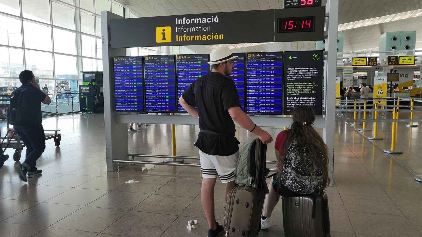 Un pasajero del Aeropuerto de Barcelona observando un panel informativo