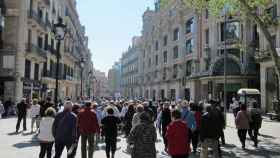 Un grupo de personas paseando por una calle barcelonesa