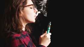 Una joven vapeando un cigarrillo electrónico de sabores