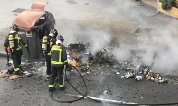 Bomberos de Barcelona apagando las llamas de un contenedor
