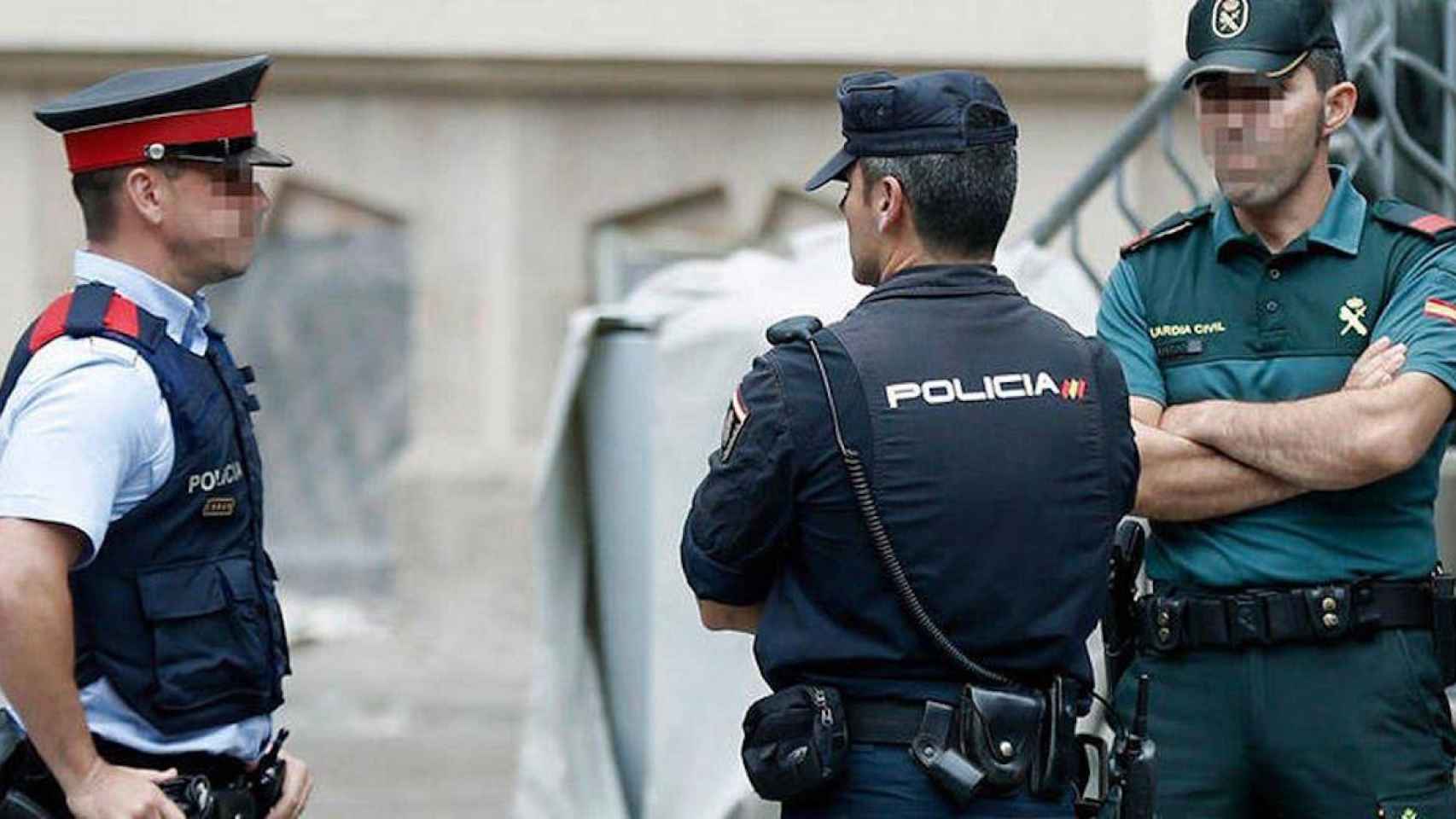 Agentes de los Mossos, la Policía Nacional y la Guardia Civil conversan en Barcelona