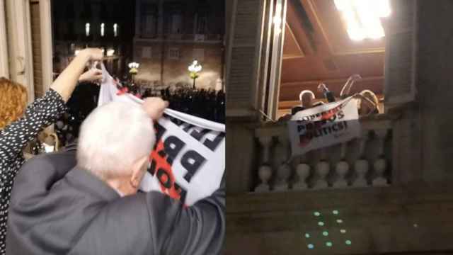 Los concejales de ERC Ernest Maragall y Elisenda Alamany cuelgan una pancarta por la libertad de los presos en la fachada del Ayuntamiento de Barcelona / TWITTER