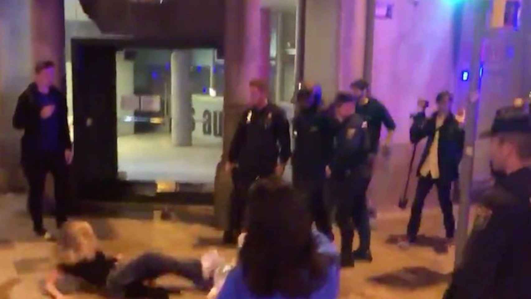 Una mujer, en el suelo, tras ser empujada por un policía / TWITTER ADRIÀ SANTASUSAGNA