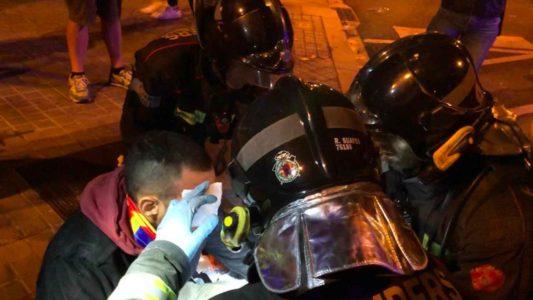 Un joven es atendido por los Bomberos tras ser herido por la policía durante los disturbios en Barcelona / ROGER VILÀ