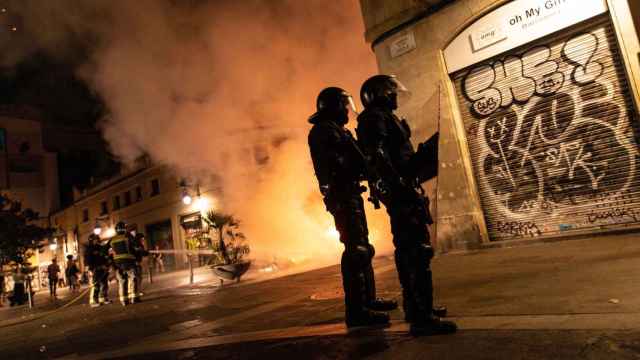 Dos agentes de la policía con un incendio de fondo / EFE