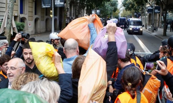 Centenares de personas arrojan bolsas de basura al perímetro de seguridad / EFE - QUIQUE GARCÍA