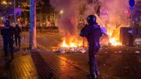 Un agente de los antidisturbios frente a una barricada durante los altercados en Barcelona / EUROPA PRESS