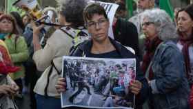 Una mujer exhibe una imagen de las cargas en la manifestación que ha reunido a 4.000 personas  / EUROPA PRESS