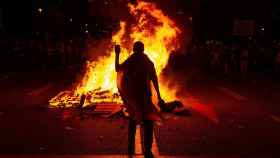 Varios manifestantes queman fotos del rey Felipe durante una protesta llevada a cabo en la avenida Diagonal de Barcelona, en protesta por la visita del rey a la capital catalana