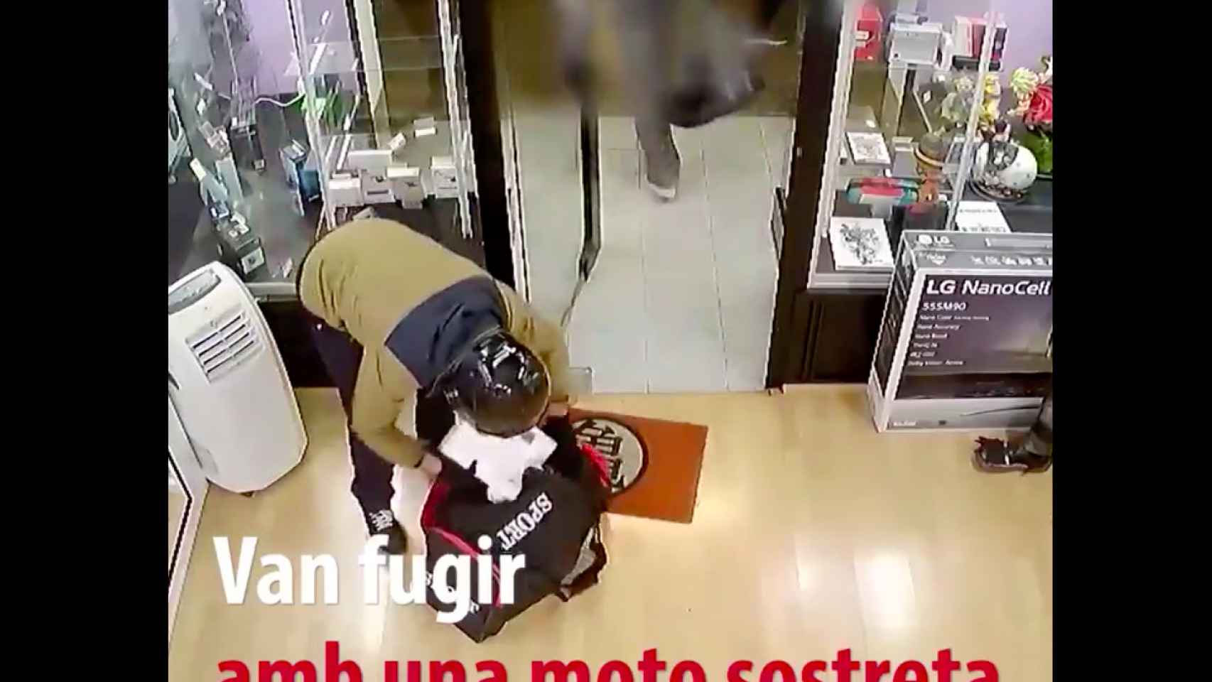 Uno de los atracadores introduce móviles robados en una bolsa / MOSSOS D'ESQUADRA