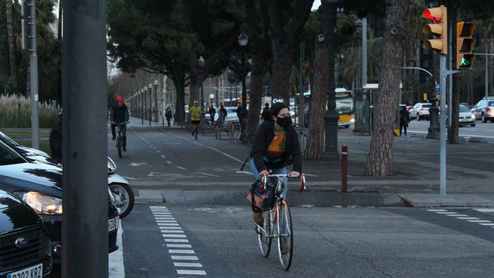 Una mujer con una mascarilla en la boca va en bicicleta por uno de los carriles habilitados en la Diagonal / AR