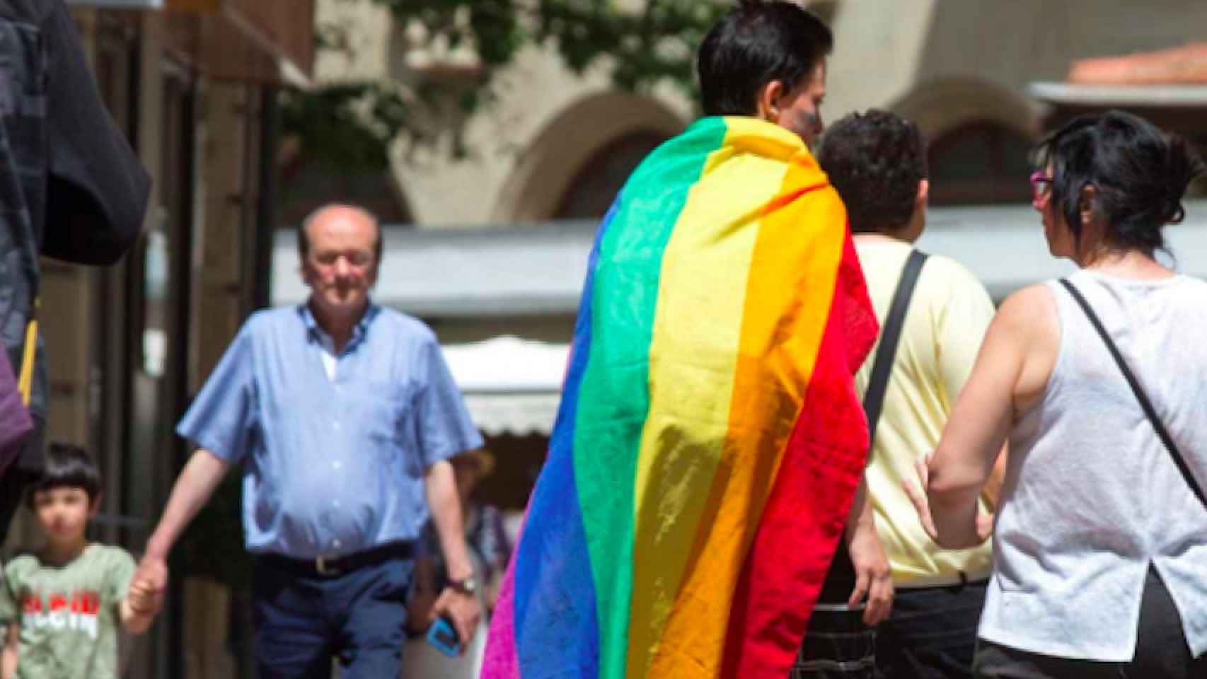 Una pareja camina por Barcelona con la bandera arcoiris contra los ataques homofóbos, emblema del colectivo LGTBI / EFE
