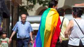 Una pareja camina por Barcelona con la bandera arcoiris contra los ataques homofóbos, emblema del colectivo LGTBI / EFE