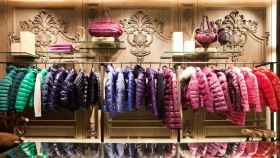 Interior de la tienda Moncler lleno de abrigos de colores