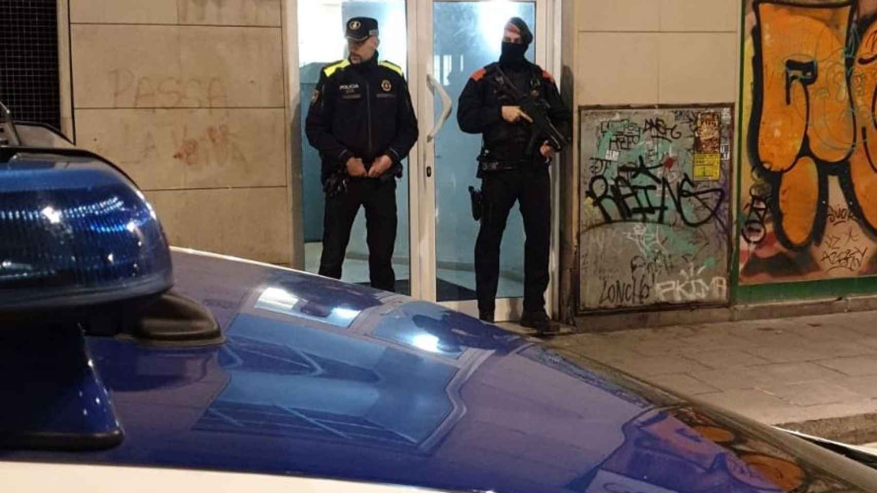 Dos policías en el exterior de una vivienda de Barcelona / Mossos d'Esquadra