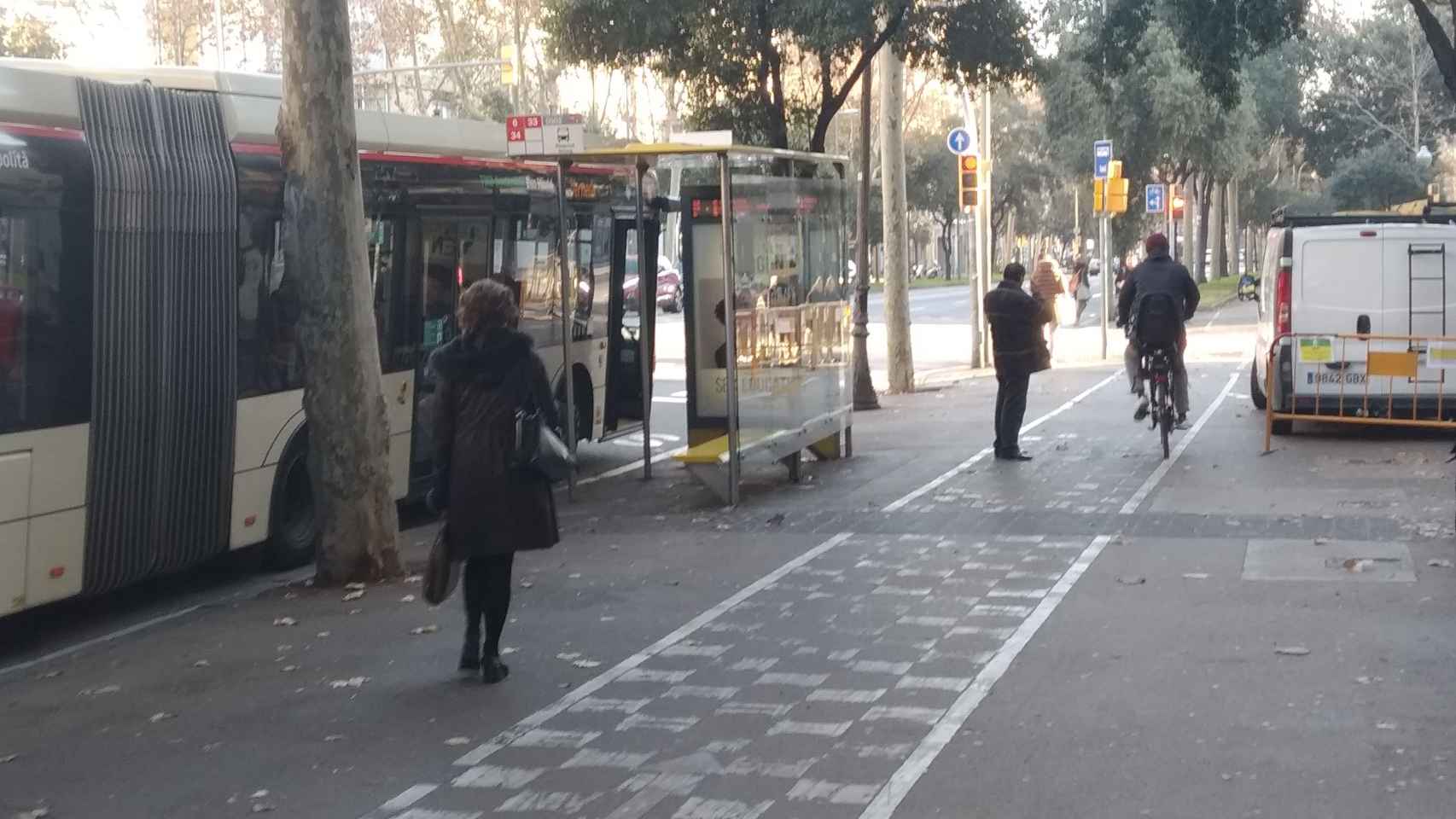 Un ciclista esquiva a un peatón junto a la parada de bus de Diagonal con Girona / JORDI SUBIRANA