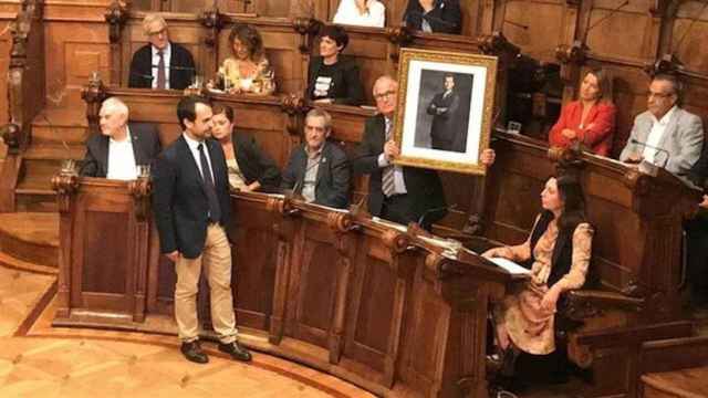 Bou, con Guilarte a la dereha, muestra una foto del Rey en el pleno / EUROPA PRESS