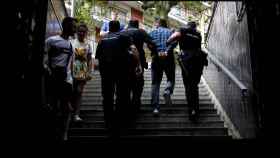 Varios policías se llevan detenida a un carterista del metro de Barcelona / EFE