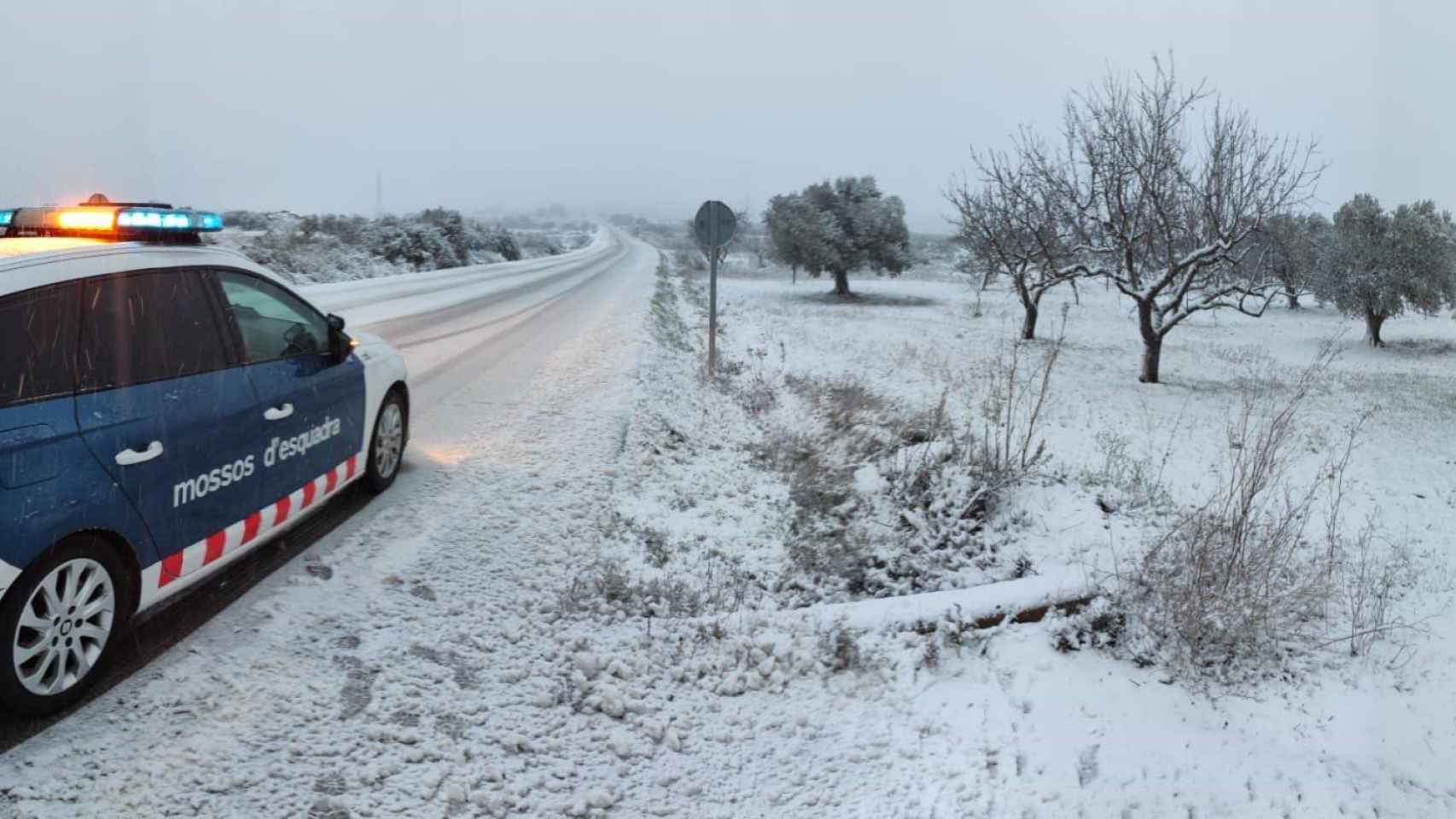 Una carretera llena de nieve con un coche de los Mossos d'Esquadra / EP