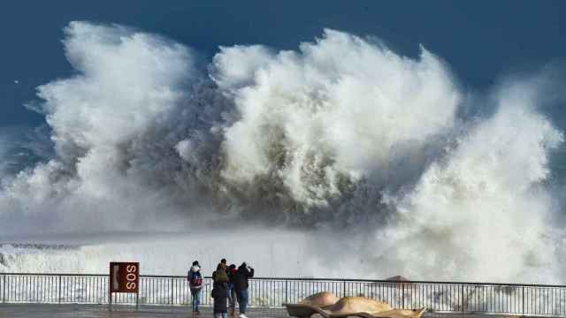 Varias personas observan las grandes olas en la playa de la Barceloneta, en Barcelona / EFE - ENRIC FONTCUBIERTA