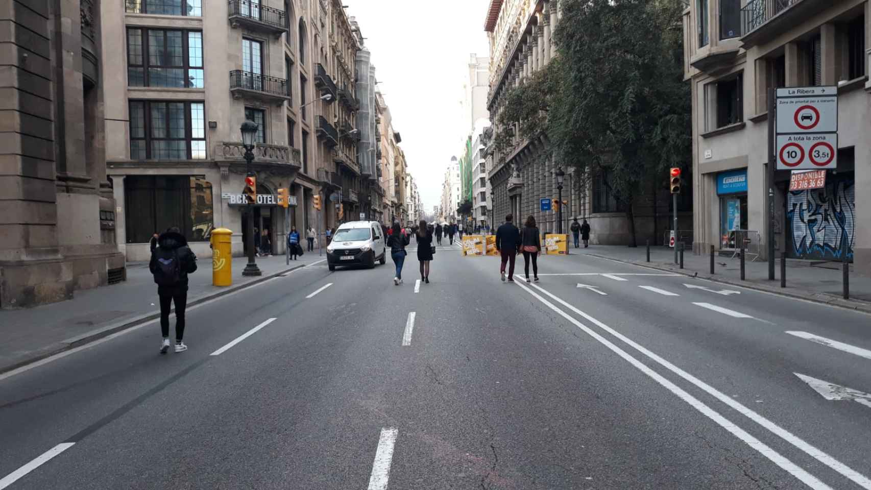 Una furgoneta circula entre unos peatones en Via Laietana / M A