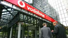 Exterior de las oficinas de Vodafone con dos personas entrando