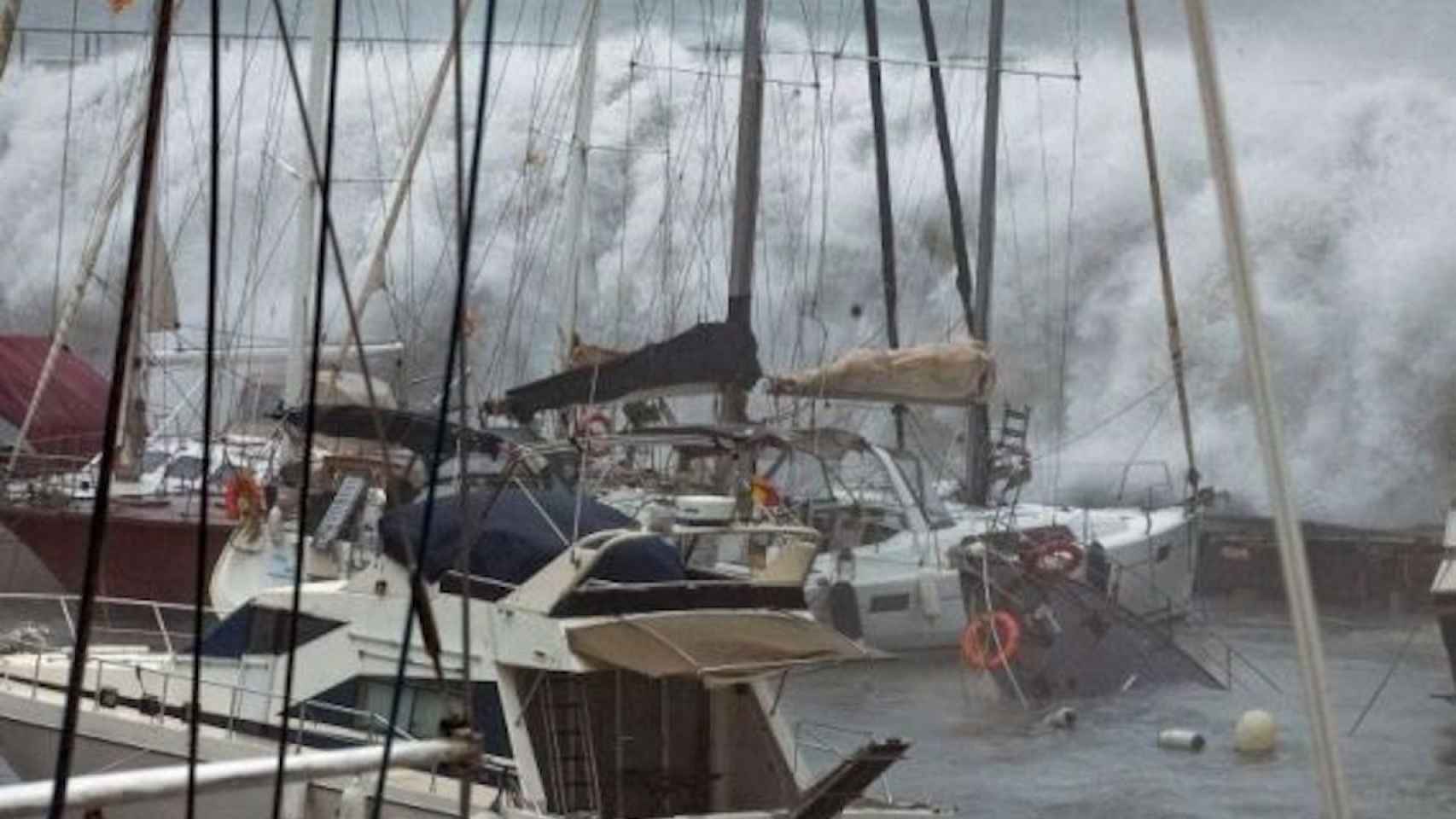 Las olas arremeten contra unas embarcaciones del Port Olímpic durante el último temporal / EFE