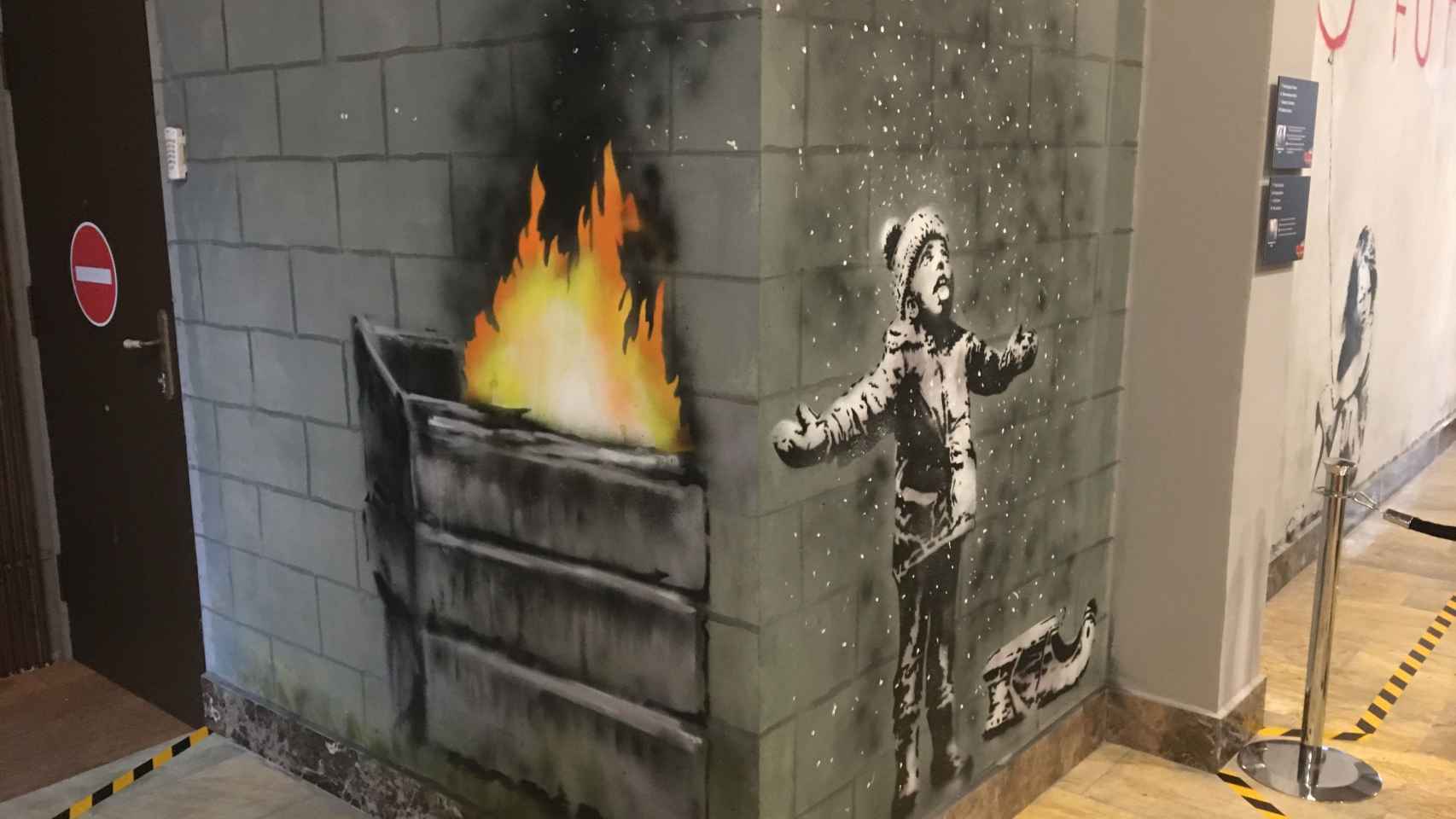 Obra de Banksy donde un niño juega con la nieve aunque en realidad son las cenizas del fuego