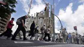 Un grupo de personas cruza un paso de peatones delante de la Sagrada Familia / EFE