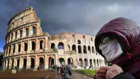 Una persona delante del Coliseo de Roma con una mascarilla