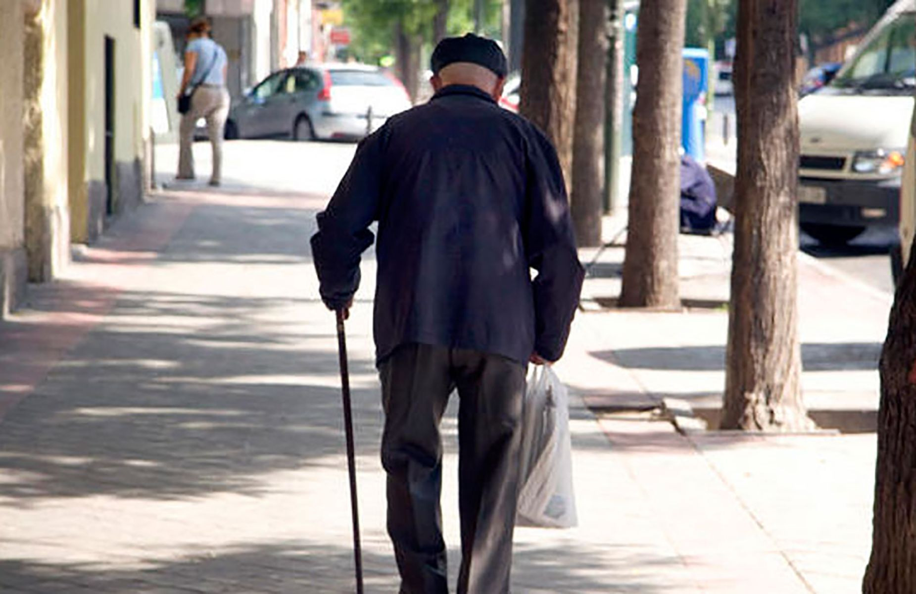 Un anciano andando por una calle de Barcelona