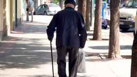Un anciano andando por una calle de Barcelona