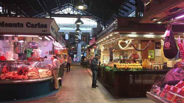 Un cliente comprando en una parada de la Boquería, vació por el coronavirus