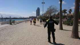 Un guardia urbano para a unos turistas en la playa / MA