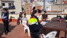 Agentes de los Mossos durante su actuación en la terraza de una casa particular en Sants / CG