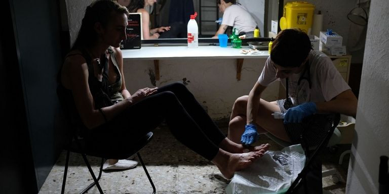 Una mujer recibe curas en sus pies en el local de Metzineres, en el Raval / LORENA ROS